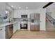 Modern kitchen with stainless steel appliances, white cabinets and hardwood floors at 9605 Carr St, Broomfield, CO 80021