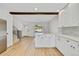 Open-concept living room featuring light wood floors, staircase, and open kitchen at 9605 Carr St, Broomfield, CO 80021