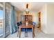 Bright dining area with a wooden table, blue chairs, built-in hutch, and a sliding door for balcony access at 955 Eudora St # 708E, Denver, CO 80220