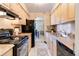 Functional kitchen with black appliances, light wooden cabinets, and adjacent dining area at 955 Eudora St # 708E, Denver, CO 80220