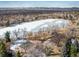 Aerial view featuring a lake, tennis courts, and the surrounding community in winter at 4470 W Lakeridge Rd, Denver, CO 80219