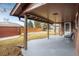 A covered back patio with views of the backyard and access to an outdoor shed at 4470 W Lakeridge Rd, Denver, CO 80219