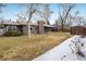 A spacious backyard with mature trees, lawn, shed, and covered patio at 4470 W Lakeridge Rd, Denver, CO 80219