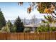 Mountain view behind a wood fence, with trees scattered through the yard at 4470 W Lakeridge Rd, Denver, CO 80219