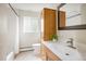 Bright bathroom featuring oak cabinetry, white countertops, and a shower with a neutral color palette at 4470 W Lakeridge Rd, Denver, CO 80219