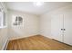 This bedroom boasts wood floors, a radiator, closet, and a bright window overlooking the driveway at 4470 W Lakeridge Rd, Denver, CO 80219