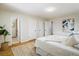 Bright bedroom with hardwood floors, white walls, and an ensuite bathroom at 4470 W Lakeridge Rd, Denver, CO 80219