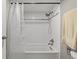 Clean white tiled tub and shower combination with modern fixtures and neutral towel at 540 S Forest St # 6-203, Denver, CO 80246