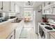 Bright kitchen with white cabinets, stainless steel sink, and dining area in the background at 540 S Forest St # 6-203, Denver, CO 80246