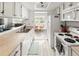 Bright kitchen with white cabinets and appliances leading into the dining area at 540 S Forest St # 6-203, Denver, CO 80246