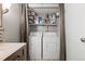 Washer and dryer closet in bathroom with shelving for laundry and bathroom supplies at 540 S Forest St # 6-203, Denver, CO 80246