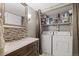 Convenient laundry closet with a washer, dryer, storage shelves, and stylish vanity at 540 S Forest St # 6-203, Denver, CO 80246