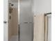 Bathroom featuring a shower with glass doors, light beige tile, and towel rack at 540 S Forest St # 6-203, Denver, CO 80246