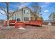Backyard view of a two-story home featuring a red-painted wooden deck and landscaping at 21541 Unbridled Ave, Parker, CO 80138