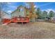 Backyard with a two-story home and red deck, with trees and blue skies above at 21541 Unbridled Ave, Parker, CO 80138