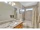 Well-lit bathroom featuring a granite countertop, a shower-tub combo, and modern fixtures at 21541 Unbridled Ave, Parker, CO 80138