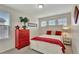 Comfortable bedroom with bright red accents, offering natural light from the large windows at 21541 Unbridled Ave, Parker, CO 80138