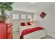 Cozy bedroom with three windows, a white bed frame, and bright red accents at 21541 Unbridled Ave, Parker, CO 80138