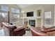 Spacious living room with a fireplace, built-in shelving, and large windows for natural light at 21541 Unbridled Ave, Parker, CO 80138