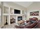 Bright living room with built-in shelving, a fireplace, and large windows for natural light at 21541 Unbridled Ave, Parker, CO 80138