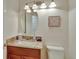 Neat half bath with granite countertop, wood cabinet, decorative mirror, and modern lighting at 21541 Unbridled Ave, Parker, CO 80138