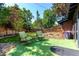 Charming backyard featuring an artificial turf area, two lounge chairs, and mature trees at 6572 E Dakota Ave, Denver, CO 80224