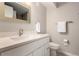 Bright bathroom features a modern vanity with white countertop, stylish faucet, and framed mirror at 6572 E Dakota Ave, Denver, CO 80224