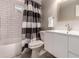 Modern bathroom with white subway tiles, a sleek vanity, and black and white shower curtain at 6572 E Dakota Ave, Denver, CO 80224