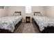 Cozy bedroom with two twin beds and an antique nightstand at 6572 E Dakota Ave, Denver, CO 80224