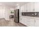 Bright kitchen features stainless steel appliances, white cabinets, and modern backsplash at 6572 E Dakota Ave, Denver, CO 80224