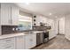 Modern kitchen featuring sleek white cabinets, stainless steel appliances, and stylish backsplash at 6572 E Dakota Ave, Denver, CO 80224
