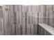 Walk-in shower with stylish vertical tile, rainfall shower head, and convenient seating at 6572 E Dakota Ave, Denver, CO 80224