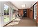 Cozy sunroom featuring brick walls, carpet, patio access, and a bistro dining set at 6572 E Dakota Ave, Denver, CO 80224