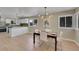 Open dining area showcasing a modern light fixture and seamless flow into adjacent kitchen space at 1596 S Stuart St, Denver, CO 80219