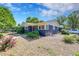 Charming home with a well-maintained rock yard and a vibrant red front door, complemented by lush greenery and blue skies at 1596 S Stuart St, Denver, CO 80219