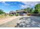 View of house featuring a detached garage with an expansive gravel driveway and a well-maintained yard at 1596 S Stuart St, Denver, CO 80219