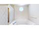 Bright bathroom with a bathtub, shower, and octagon window at 2314 Flagstaff Dr, Longmont, CO 80504
