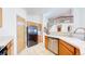 Open kitchen with oak cabinets, stainless steel dishwasher, and bright countertops at 2314 Flagstaff Dr, Longmont, CO 80504