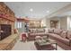 Finished basement with a stone fireplace, a comfortable sofa, and a kitchenette at 1 Gooseberry Ln, Cherry Hills Village, CO 80113