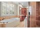 This bathroom features a soaking tub, a walk-in shower, and wood cabinetry at 1 Gooseberry Ln, Cherry Hills Village, CO 80113