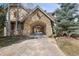 Stone archway and driveway surrounded by mature trees and landscaped grounds at 1 Gooseberry Ln, Cherry Hills Village, CO 80113