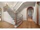 Grand foyer featuring hardwood floors, curved staircase, and decorative wrought iron railing at 1 Gooseberry Ln, Cherry Hills Village, CO 80113