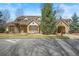Charming home featuring stone accents, wood shutters, a porte-cochère and professionally landscaped yard at 1 Gooseberry Ln, Cherry Hills Village, CO 80113