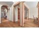 Elegant hallway featuring hardwood floors, arched doorways, and decorative wood beam accents at 1 Gooseberry Ln, Cherry Hills Village, CO 80113