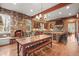 Rustic kitchen and dining area featuring stone walls, hardwood floors, and a cozy fireplace at 1 Gooseberry Ln, Cherry Hills Village, CO 80113