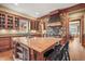 Gourmet kitchen featuring a large island, stone wall, and custom cabinetry at 1 Gooseberry Ln, Cherry Hills Village, CO 80113