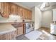 Functional laundry room with custom cabinets, a copper sink and modern appliances at 1 Gooseberry Ln, Cherry Hills Village, CO 80113
