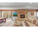 Cozy living room featuring a stone fireplace, exposed beams, and patio access at 1 Gooseberry Ln, Cherry Hills Village, CO 80113