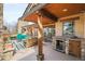 Inviting outdoor living area featuring stone accents, wood beams, and built-in bar area at 1 Gooseberry Ln, Cherry Hills Village, CO 80113