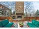 Outdoor patio featuring a stone fireplace, wood railing, and comfortable seating at 1 Gooseberry Ln, Cherry Hills Village, CO 80113
